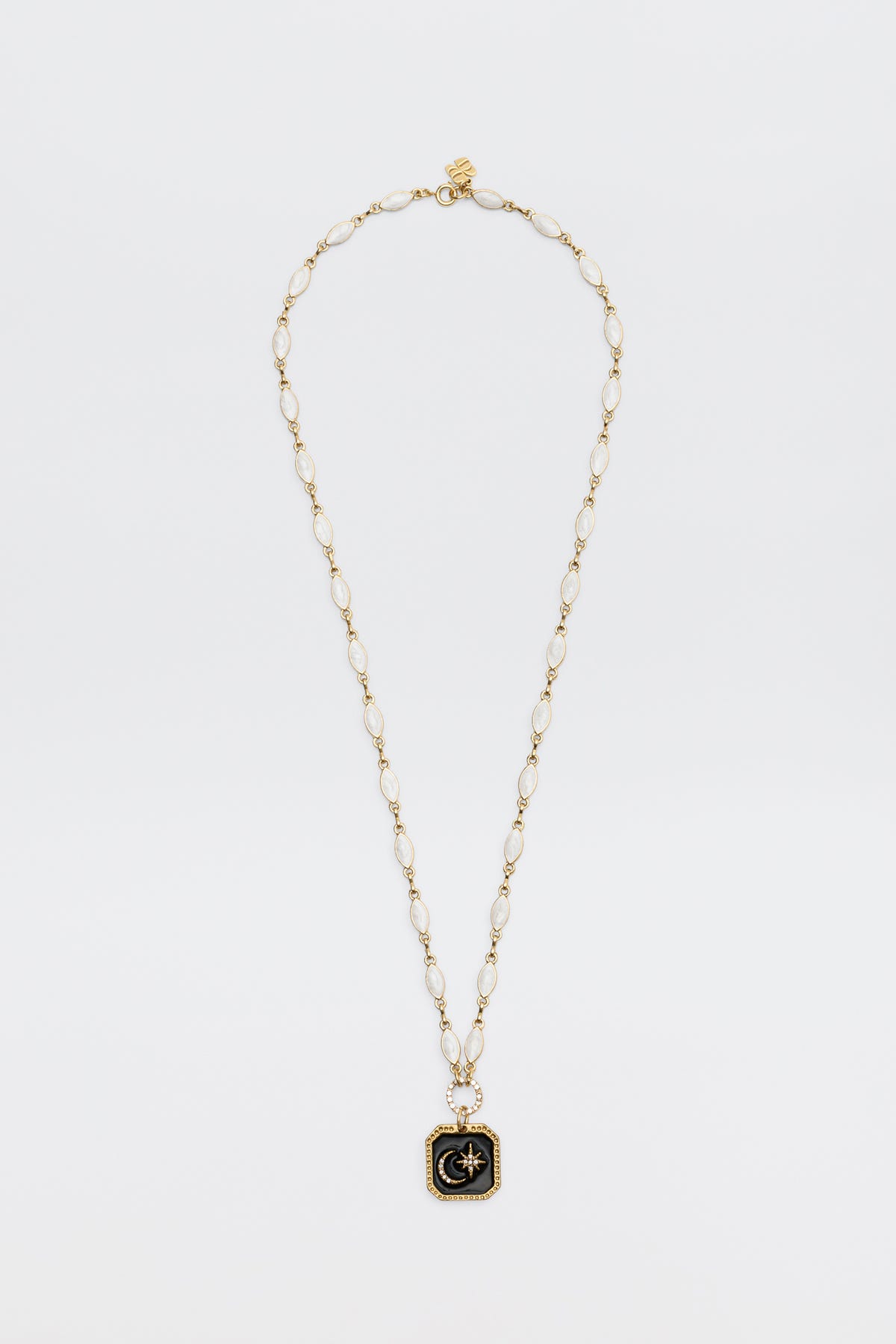 A gold chain necklace named “Kathryn - Pearl,” featuring oval links and a square black pendant adorned with a gold starburst design at the center, displayed on a white background.