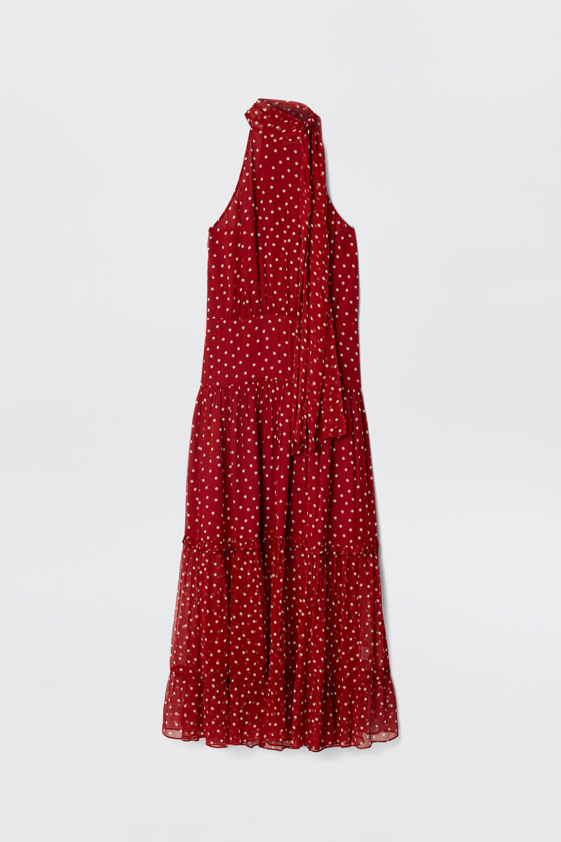 Abi - Layla Dot Red is a sleeveless red midi dress in crinkled chiffon with white polka dots, a tiered skirt, and a long matching scarf or tie at the neckline, shown against a plain white background.
