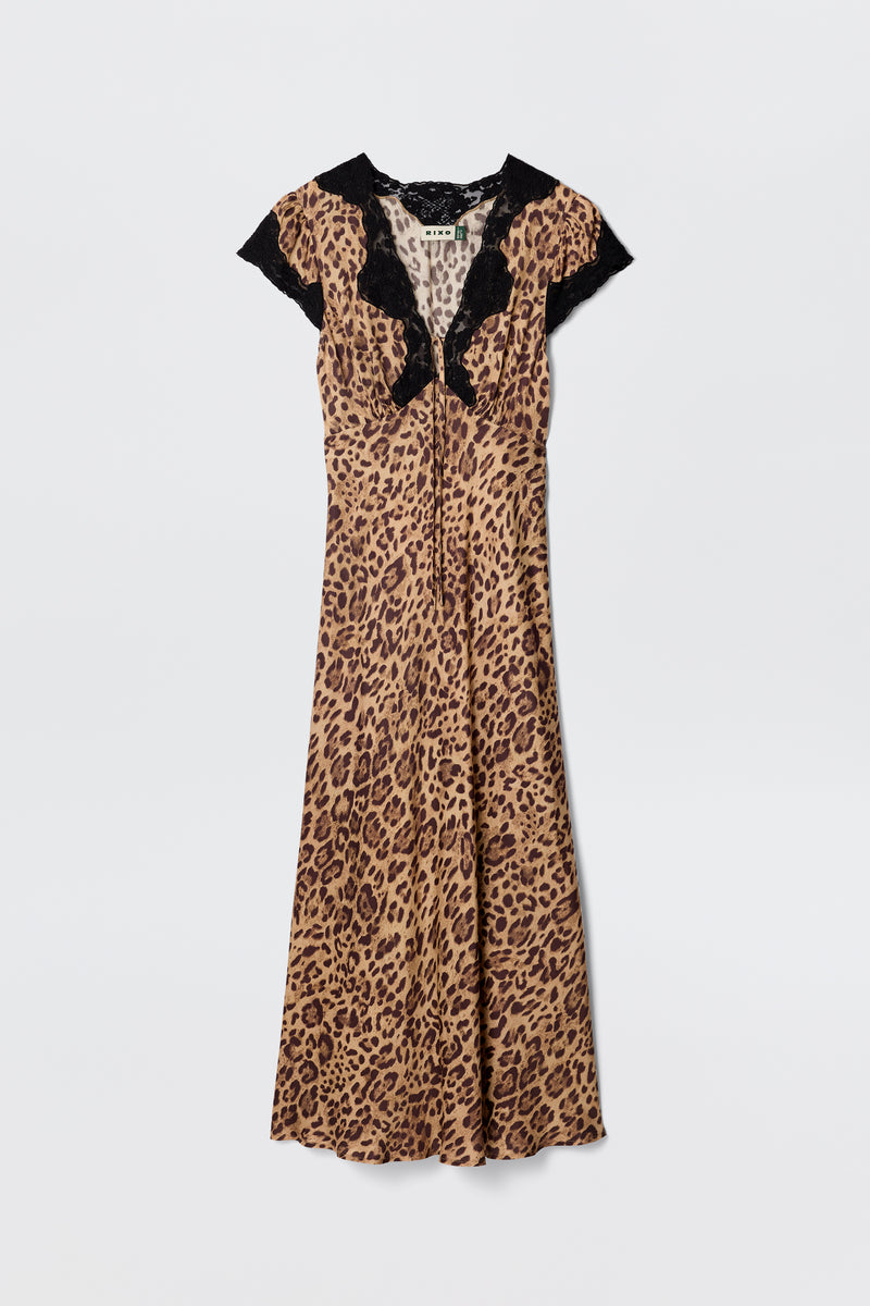 The Amari - Mila Leopard Brown is a short-sleeved, bias-cut leopard print dress with black lace trim at the neckline and shoulders, shown against a plain white background.