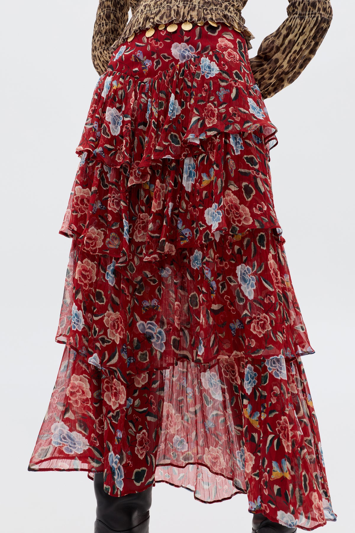 A person wearing the Taryn - Butterfly Floral Burgundy skirt, a tiered ruffled red prairie style in crinkled georgette, is shown from the waist down paired with a leopard print top.