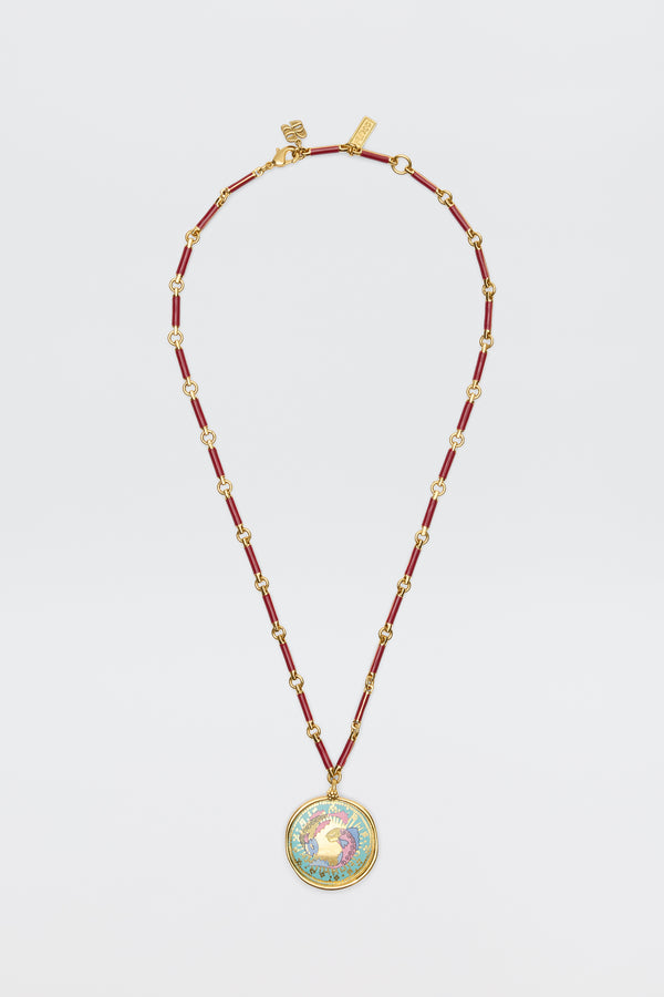 Ari - Astro Pisces: A gold and red beaded necklace featuring a circular statement disc pendant with a colorful rooster design on a white background, displayed against a white surface.