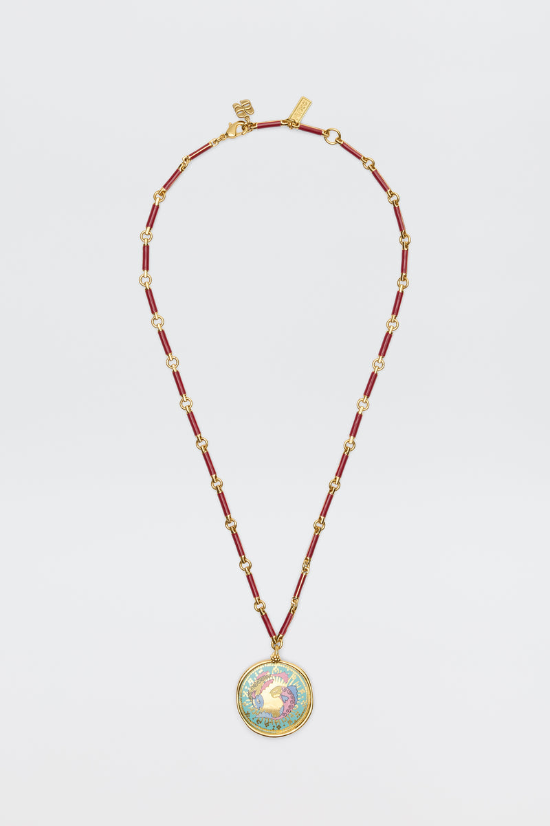 Ari - Astro Pisces: A gold and red beaded necklace featuring a circular statement disc pendant with a colorful rooster design on a white background, displayed against a white surface.