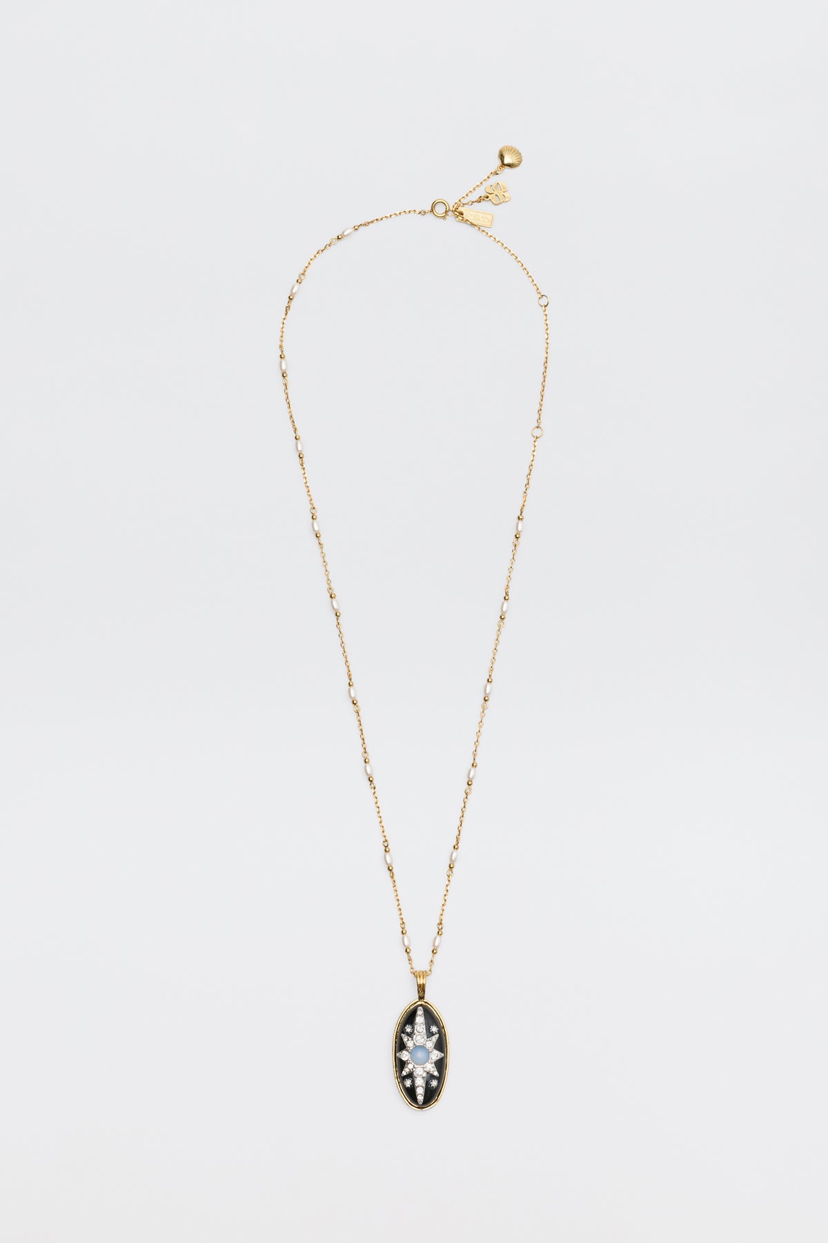 Introducing the Andi - Black necklace: a delicate gold chain adorned with small beads and an oval pendant, featuring a clear marquise-cut gemstone set in a striking black and gold frame, beautifully displayed on a white background.