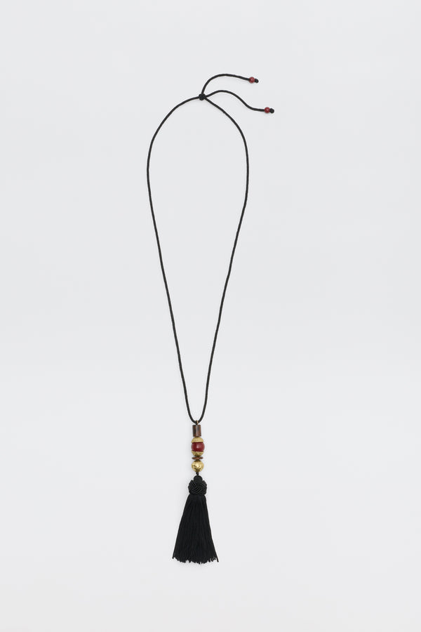 Rossa - Black cord necklace featuring gold and red accent beads and a black tassel pendant.