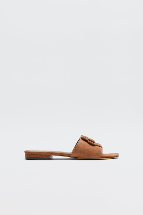 The Kenna - Brown sandal features an open toe and wide, knotted strap, ideal for summer outfits, shown against a plain white background.