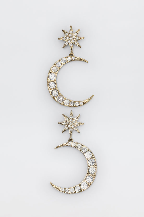 Theresa - Gold earrings featuring a gold-tone star and crescent moon drop design encrusted with clear crystals.