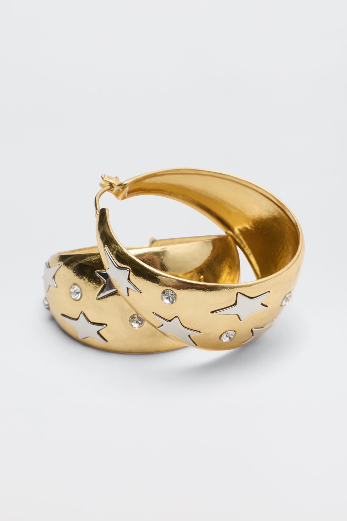 Sergio - Gold hoop earrings featuring silver star-shaped inlays and embedded clear crystals.