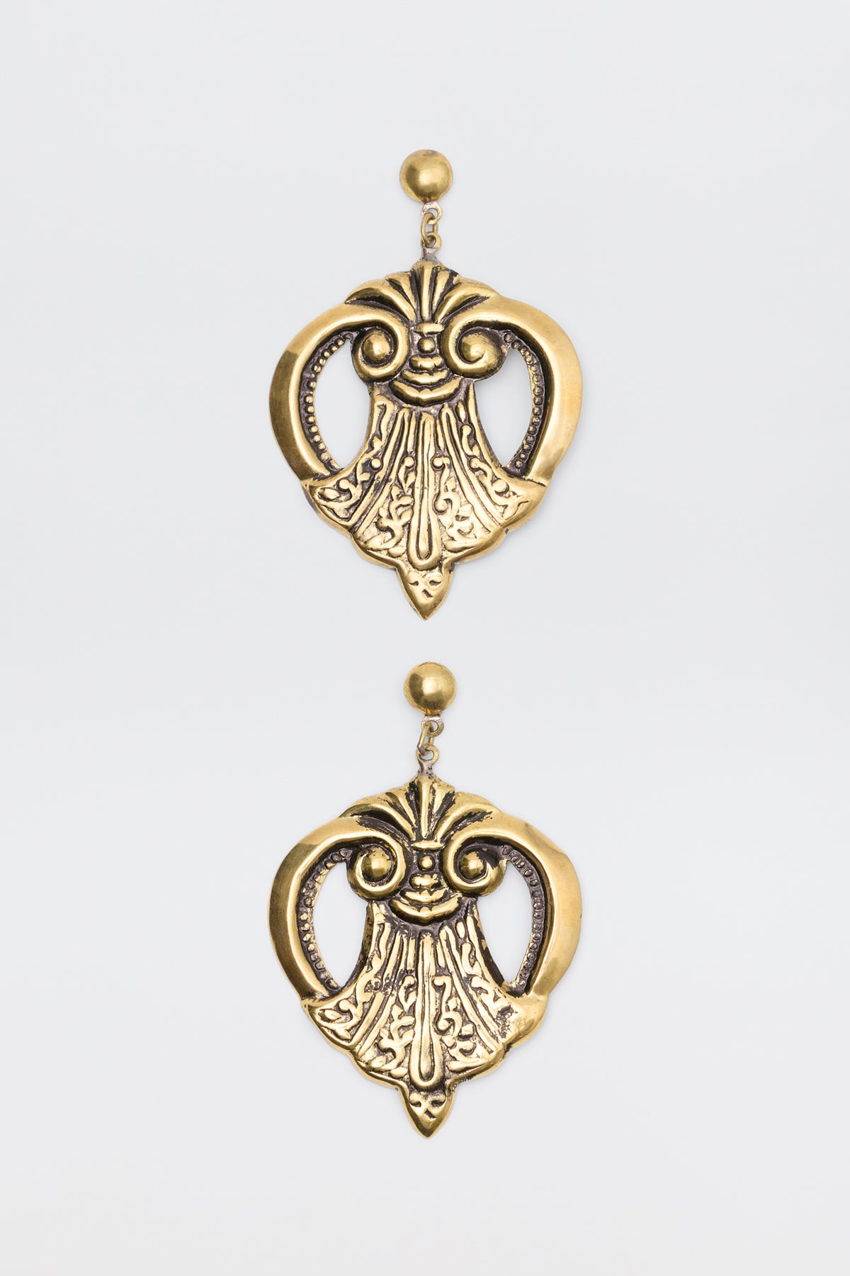 Julieta Earrings Gold featuring ornate, symmetrical scrollwork designs hanging from stud posts.