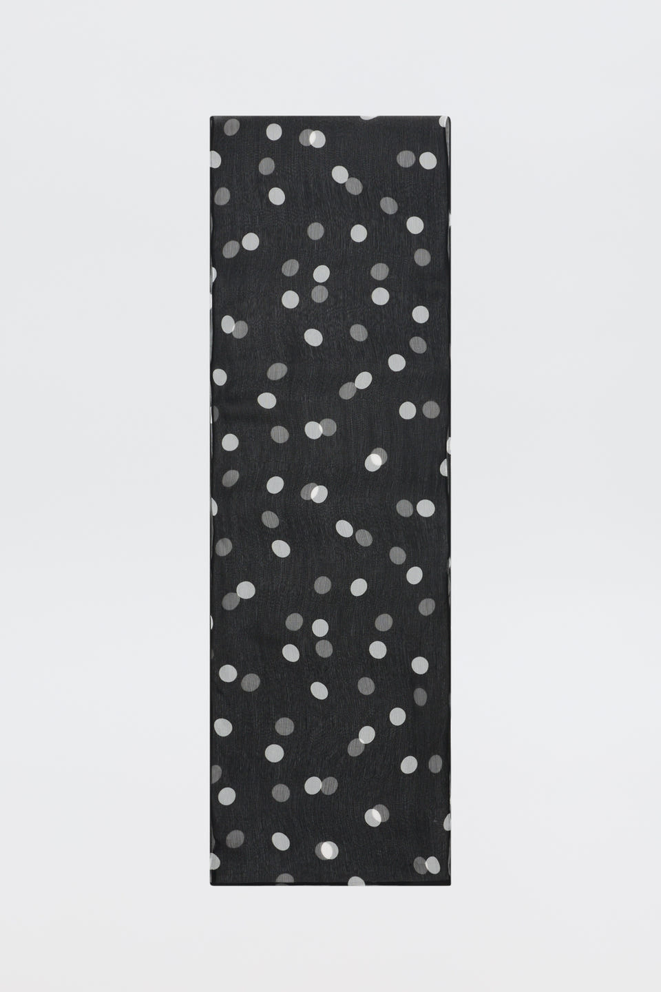 A tall, rectangular object named “Julien - Cosmos Spot Black,” featuring a pattern of scattered white polka dots on its black surface, is placed against a plain white background.