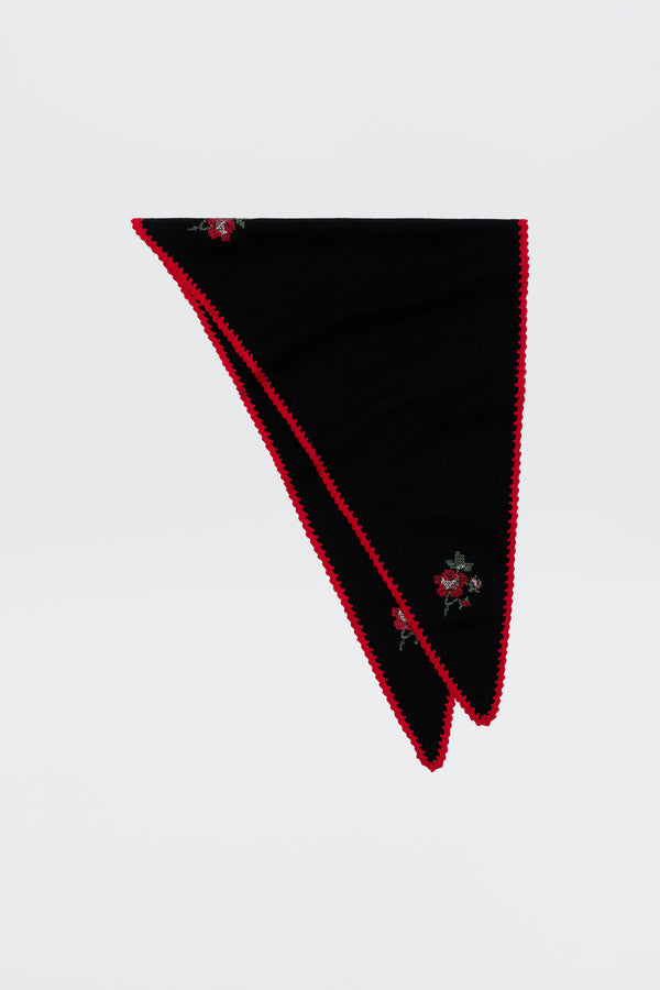 Sure! Here’s a rewritten sentence using your product data: The Lianora - Abi Rose Knit Black features a black triangular design accented with red trim and delicate embroidered red roses, shown folded neatly on a plain white background.