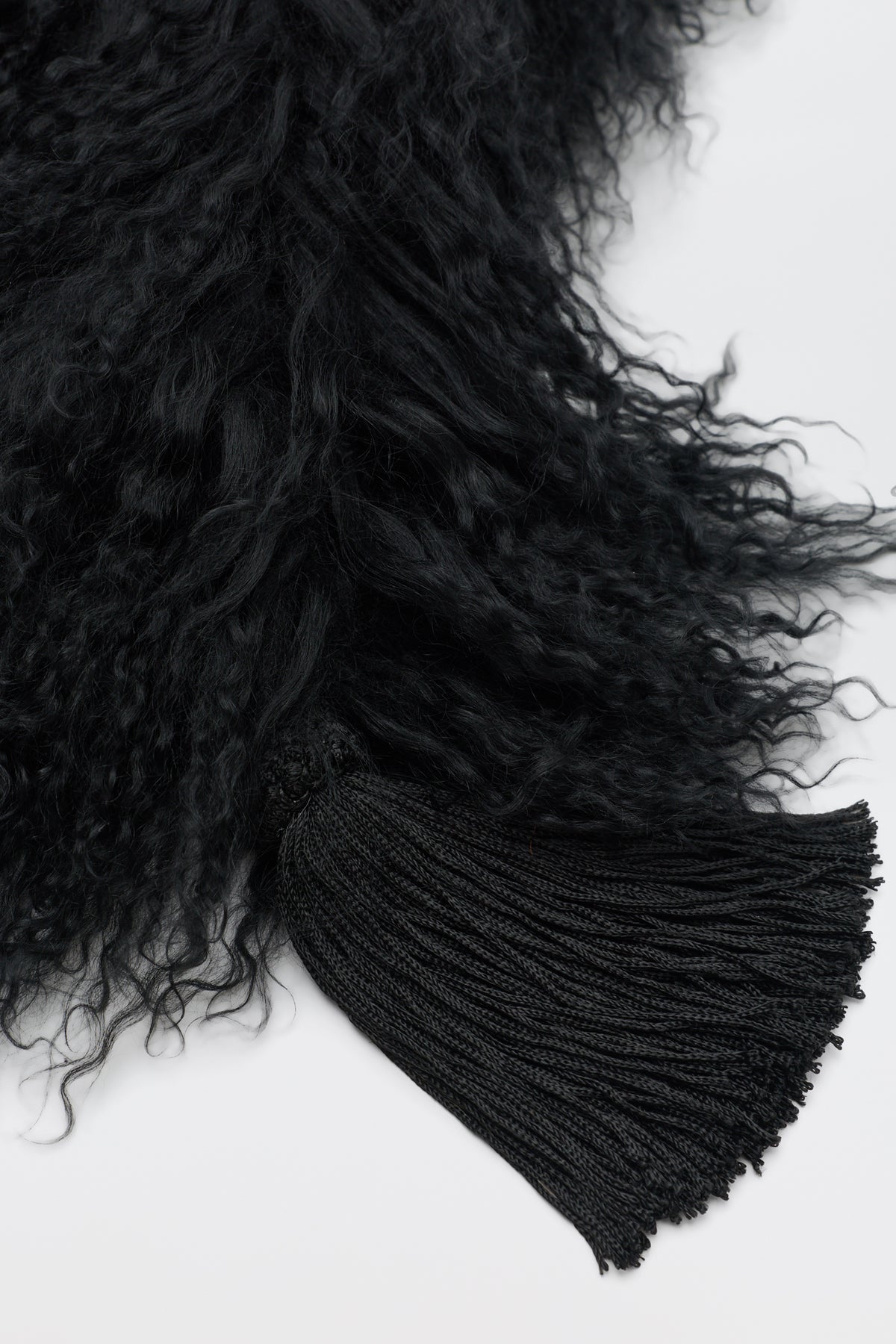 Kove - Black featuring black curly textured material with a large matching tassel attached.