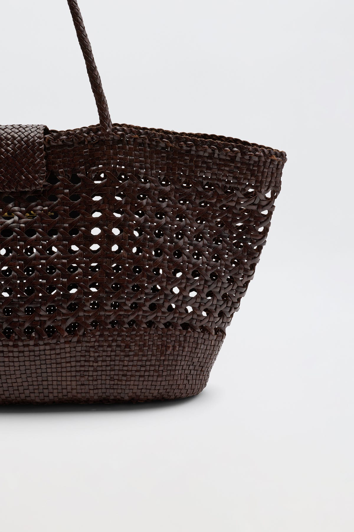 A close-up of the Lucine - Dark Brown bag, showcasing its open weave pattern and handle against a plain light background—an elegant piece that embodies the signature Dragon Diffusion style.