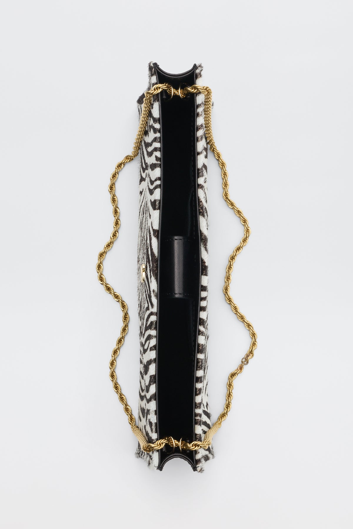 Top-down view of the Kamila - Zebra Print Brown rectangular clutch bag featuring a brown and white zebra print and a gold-tone rope chain strap.