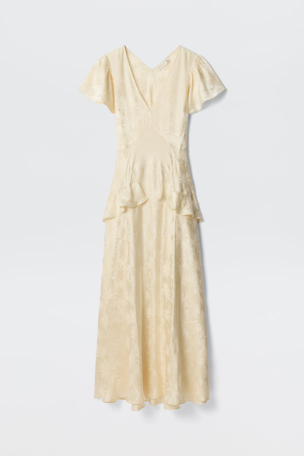 The Evie - Daisy Jacquard Champagne is a cream midi dress in silk-jacquard, featuring short sleeves, a V-neckline, subtle floral pattern, and waist ruffles—elegantly showcased against a plain white background.
