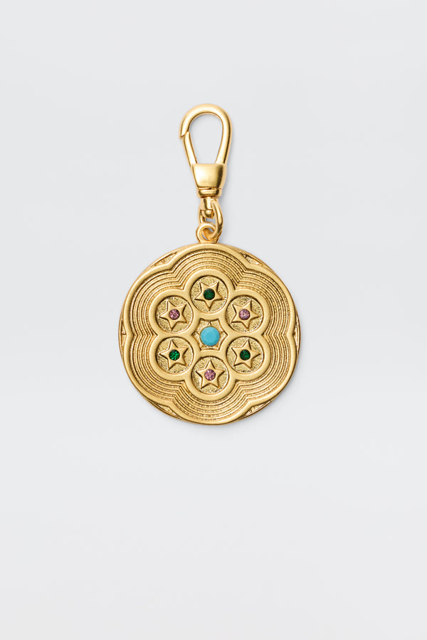 Chelle - Gold is a vintage-finished, gold-plated round charm pendant with engraved patterns and five star motifs set with colorful green, turquoise, or pink gems, secured by a swivel clasp.