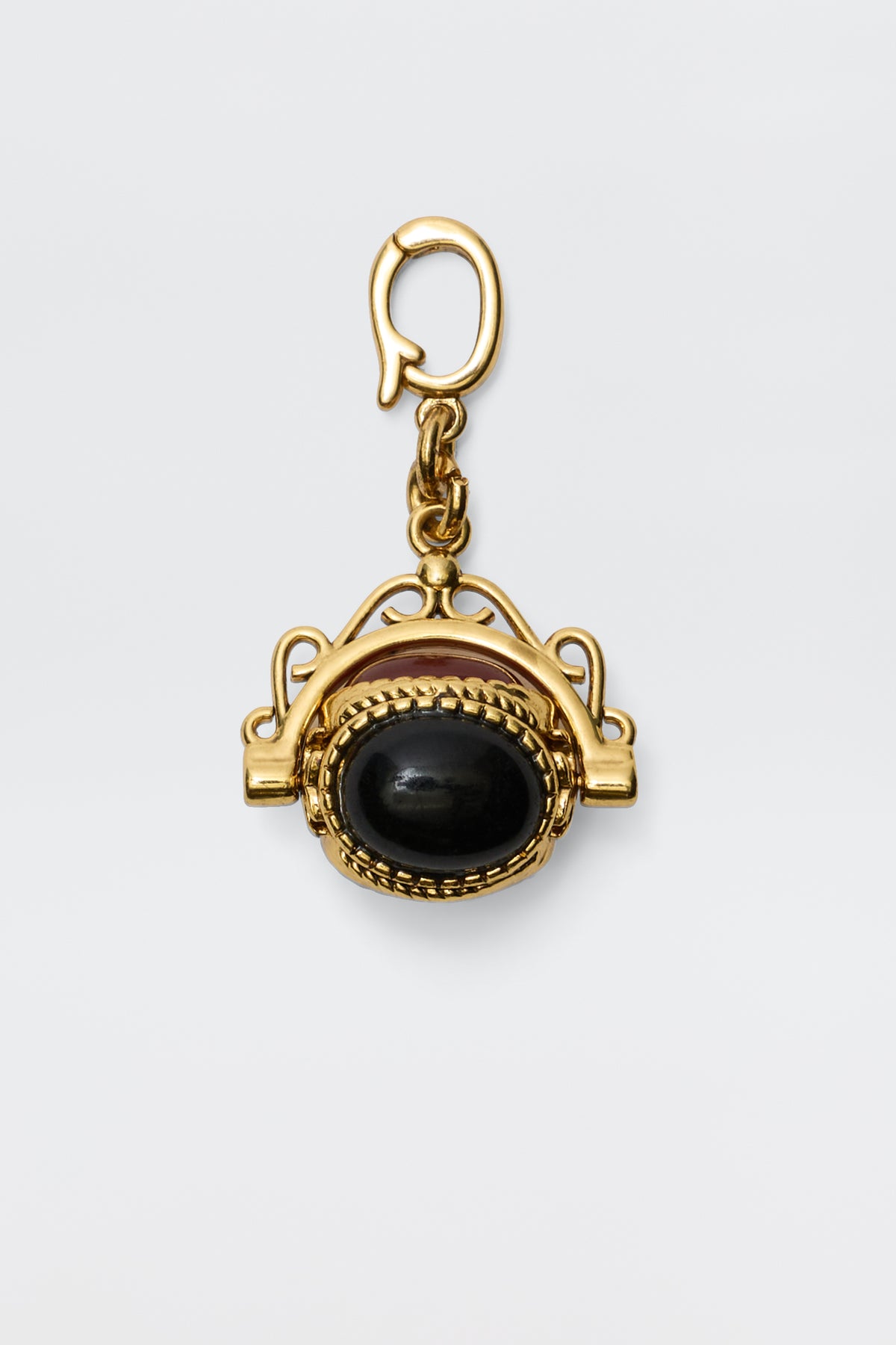 Sariah - Gold is an 18-karat gold-plated pendant featuring a large oval semi-precious stone in an intricate frame, hanging from a decorative clasp and radiating vintage charm against a plain white background.