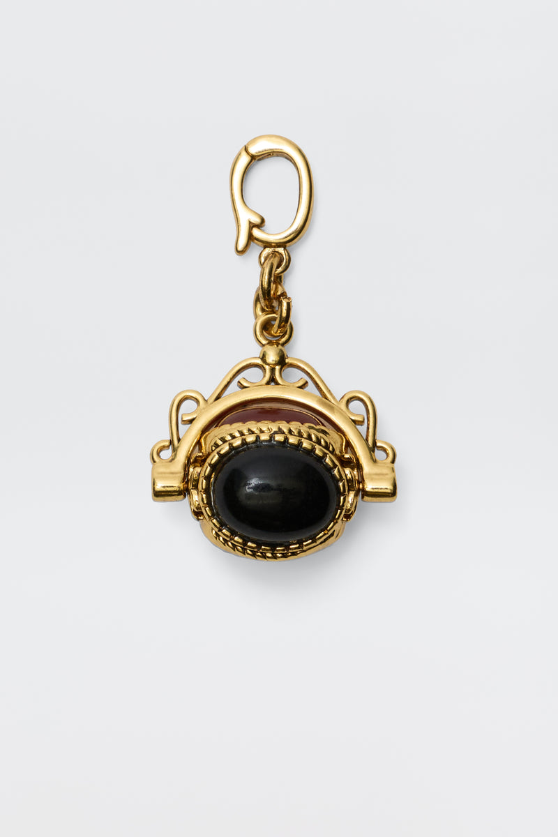 Sariah - Gold is an 18-karat gold-plated pendant featuring a large oval semi-precious stone in an intricate frame, hanging from a decorative clasp and radiating vintage charm against a plain white background.