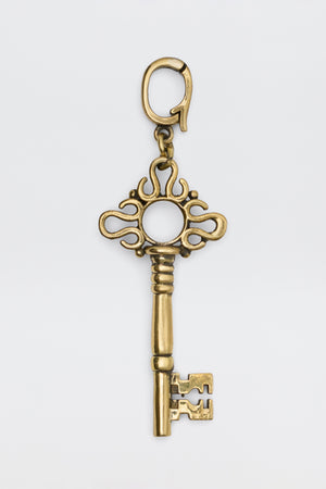 Arleth - Gold decorative key charm with an ornate bow and a lobster clasp.