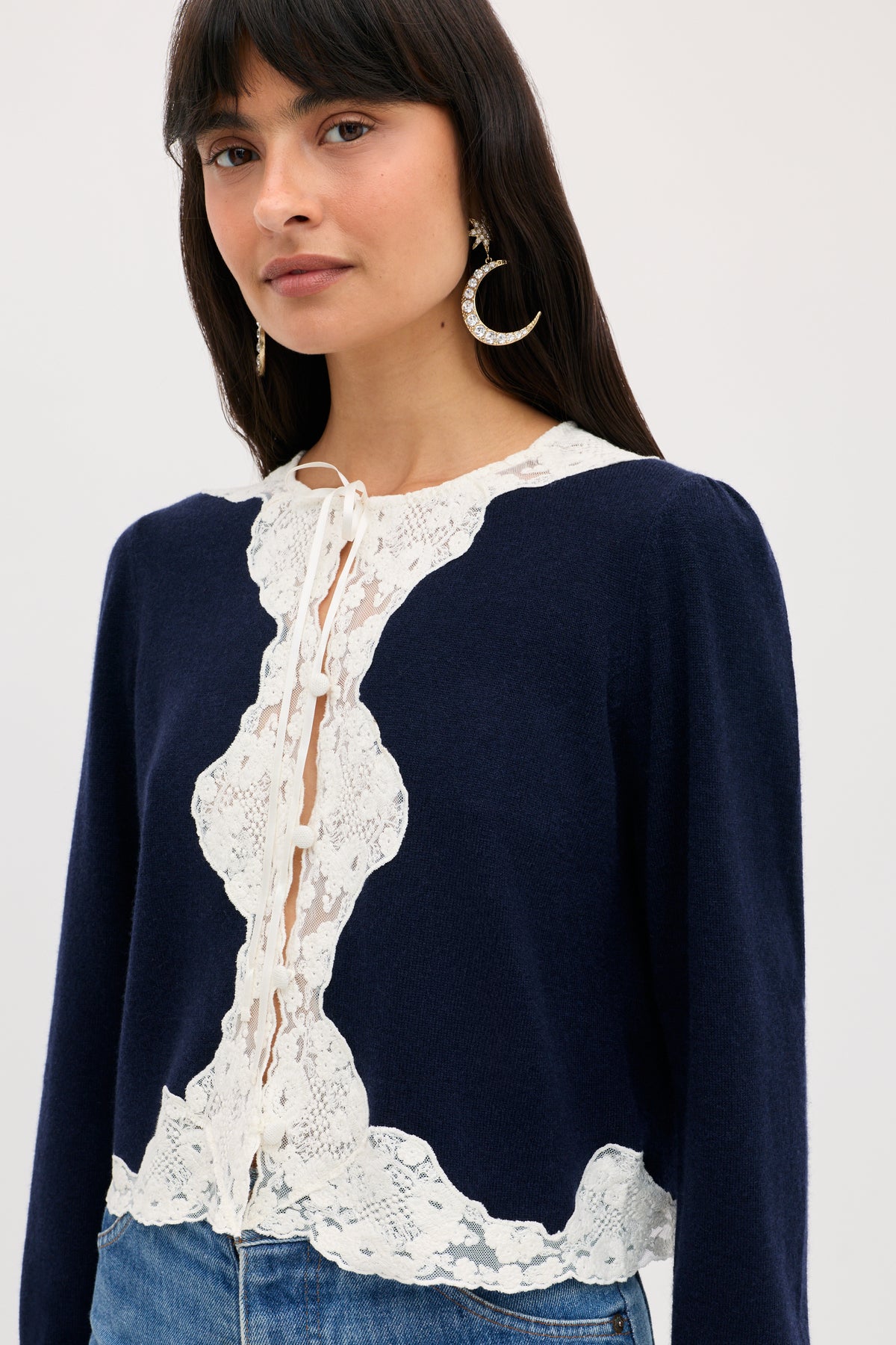 Tassia - Navy cardigan in navy blue with a white lace trim along the button-front closure.