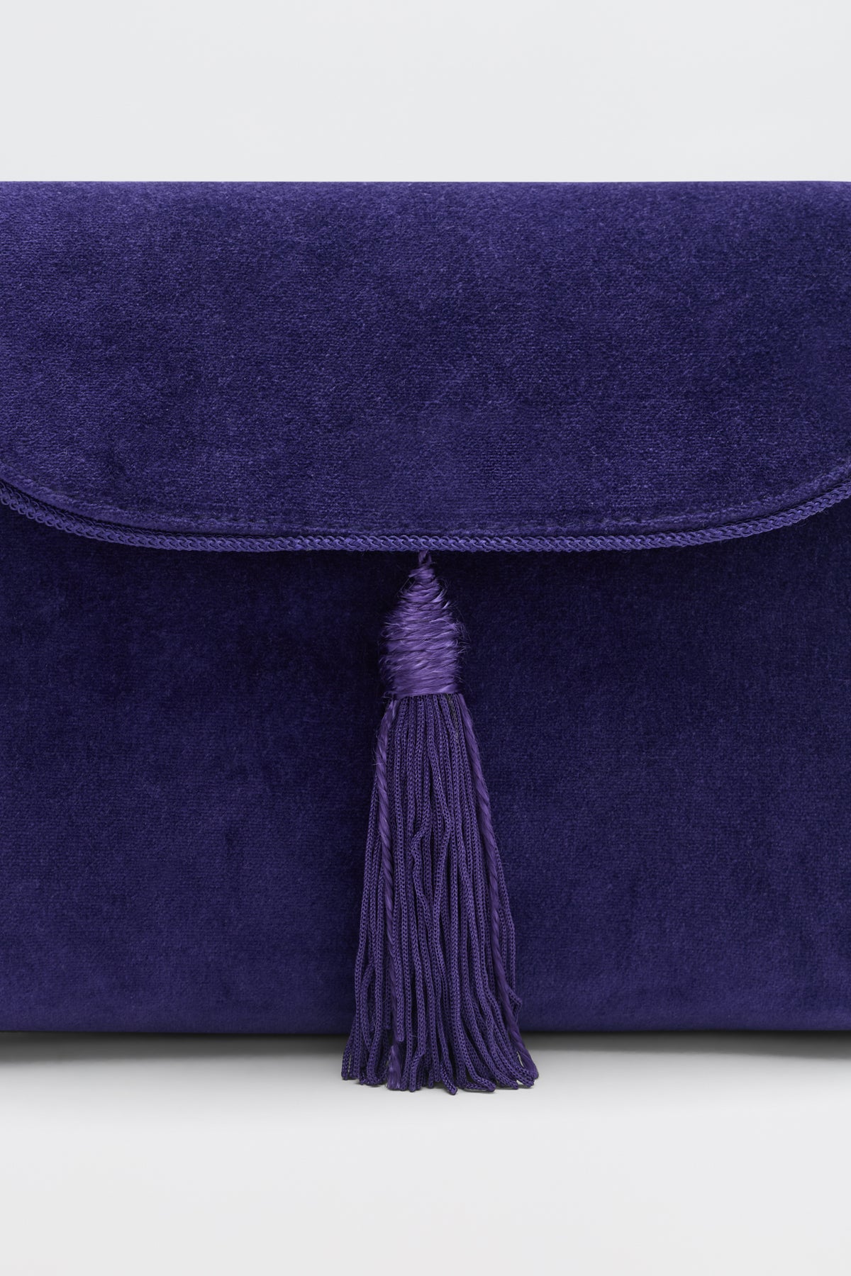 Jeany - Purple clutch bag with a fold-over flap and a decorative tassel.