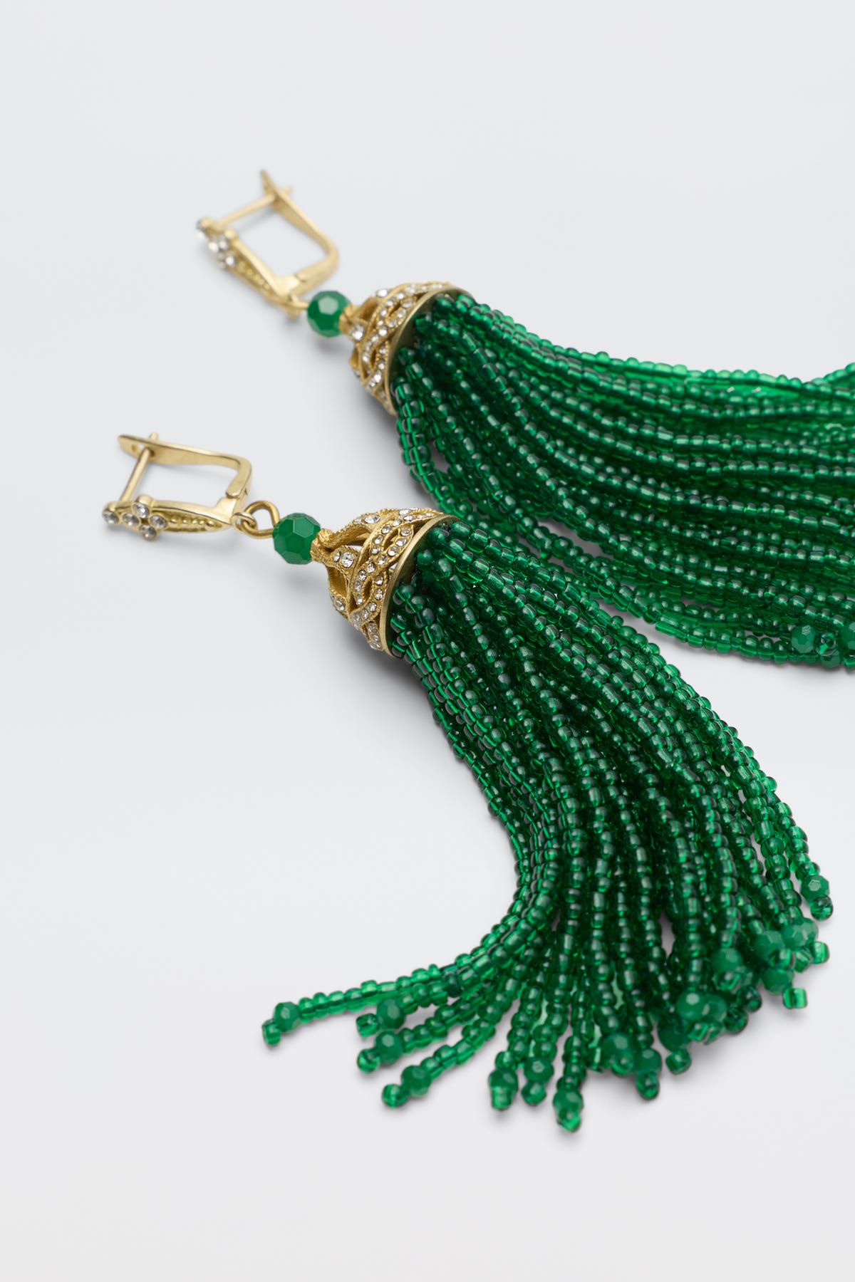 Alea - Green gold earrings featuring green beaded tassels suspended from ornate, crystal-accented caps.