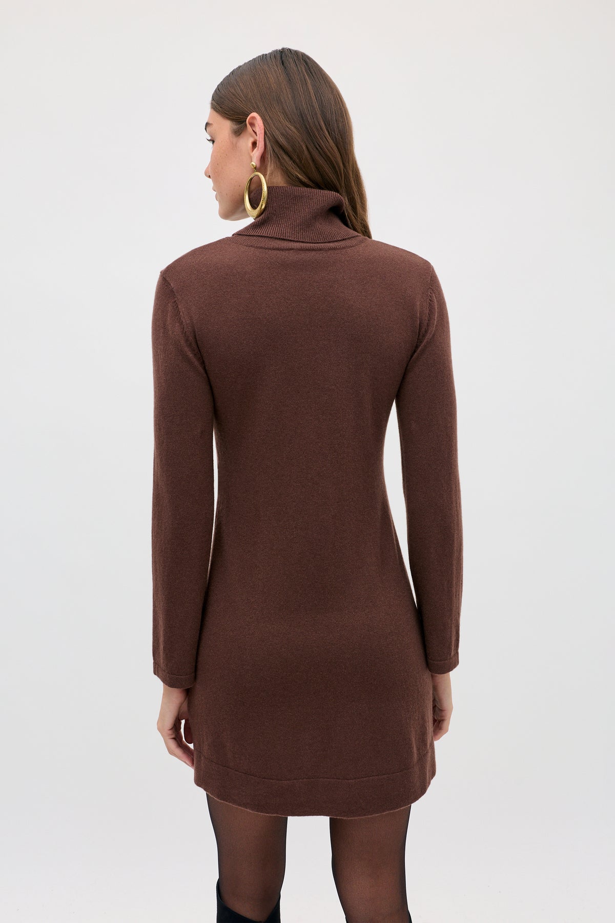 Back view of a person wearing the Aly - Chocolate brown long-sleeved turtleneck sweater dress and large gold hoop earrings.