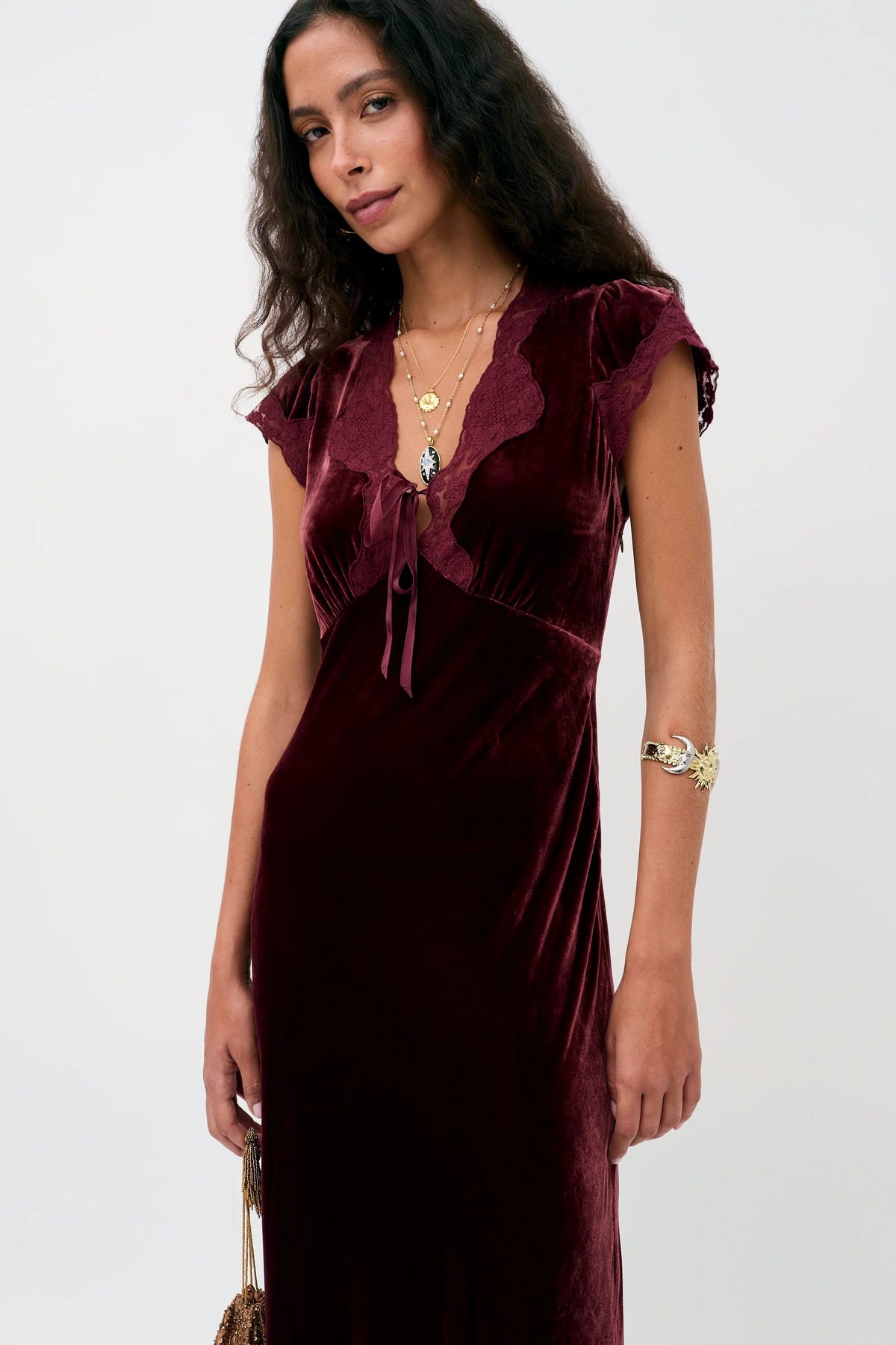 Amari - Bordeaux short-sleeved, knee-length burgundy velvet dress with a lace-trimmed V-neckline and a ribbon tie.