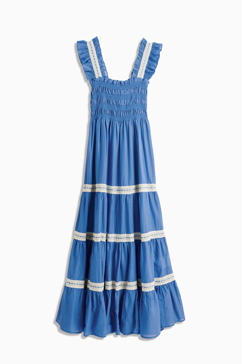 Aubrie - Blue is a sleeveless dress with ruffled straps and a smocked bodice, highlighted by delicate white lace trim on both the bodice and skirt. Its tiered skirt ends in a ruffled hem, giving this piece vintage-inspired charm reminiscent of a classic lace nightdress.