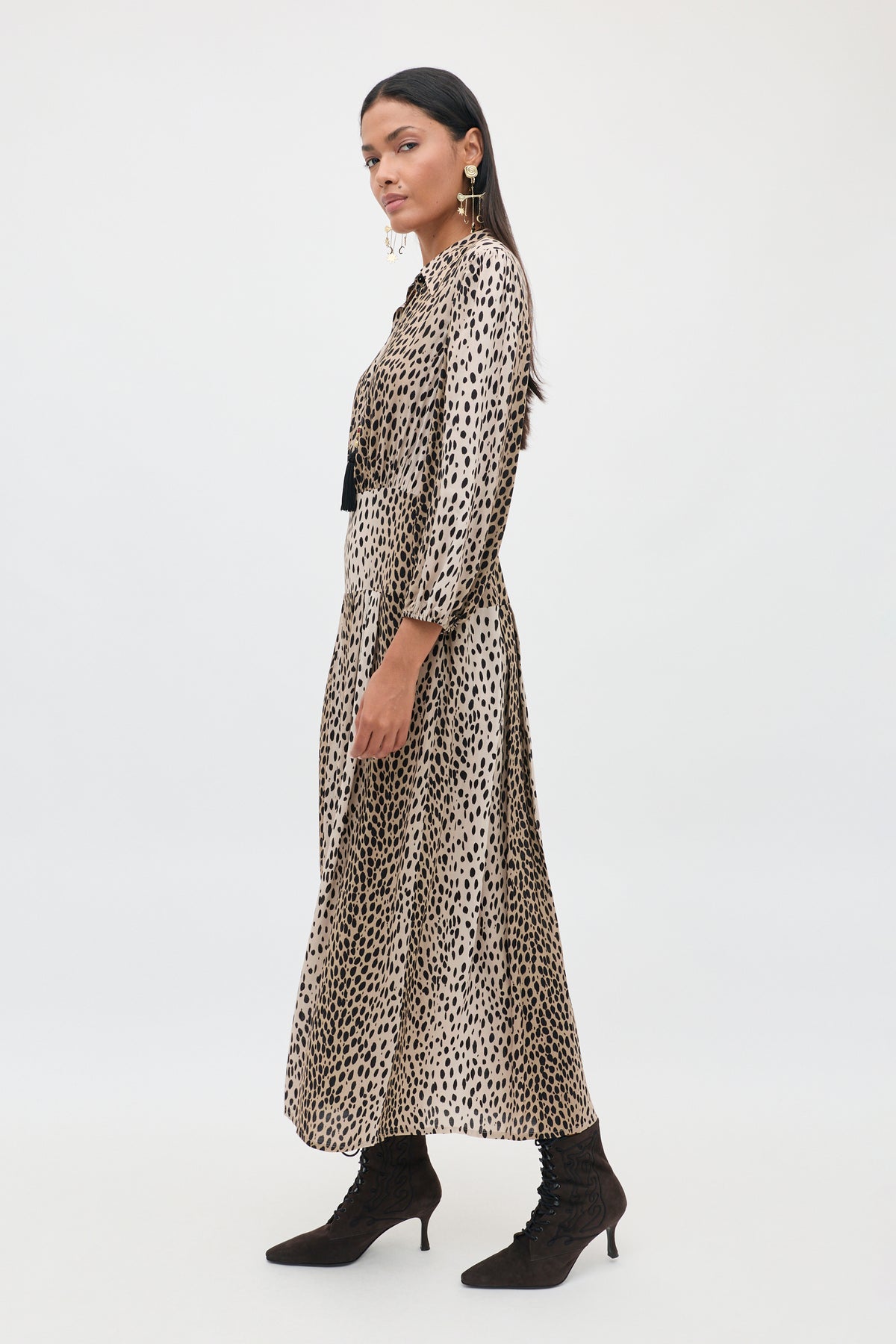 A model wears the Victoriana - Brown long-sleeved midi dress in a black-on-tan animal print, styled with brown lace-up heeled boots.