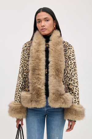 A model wears a Jorgia - Savannah Leopard Brown jacket featuring a brown leopard print with a thick, tan faux-fur collar and cuffs.