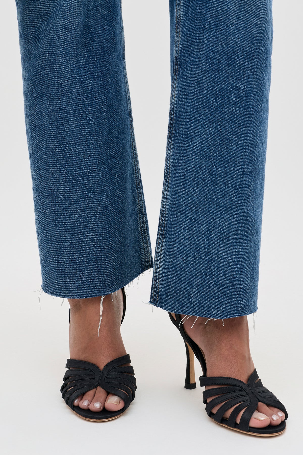 Mavi - Satin Black cropped blue jeans with a raw frayed hem worn with black strappy stiletto sandals.